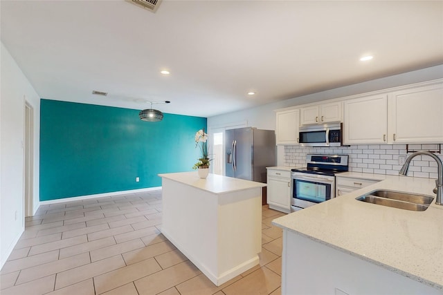 9729 Manassas Rd, Fort Worth, TX 76177 - kitchen with stainless steel appliances, a kitchen island, white cabinetry, recessed lighting, and decorative backsplash