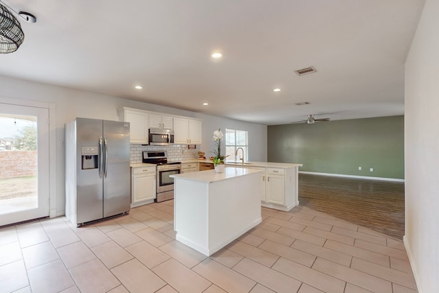 9729 Manassas Rd, Fort Worth, TX 76177 - kitchen featuring appliances with stainless steel finishes, a ceiling fan, light countertops, a peninsula, and white cabinets