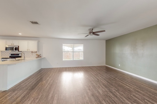 unfurnished living room featuring dark hardwood / wood-style floors and ceiling fan