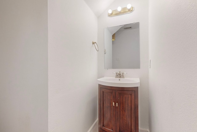 bathroom with vanity and vaulted ceiling