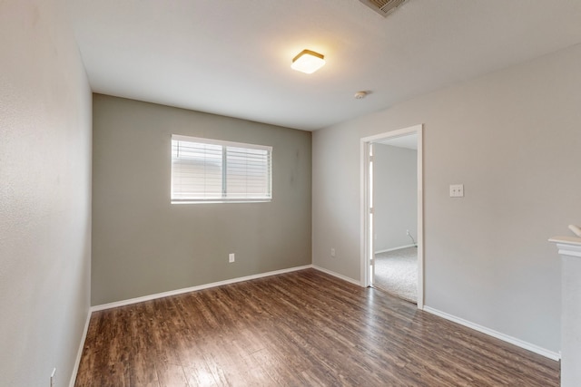 unfurnished room with dark hardwood / wood-style flooring