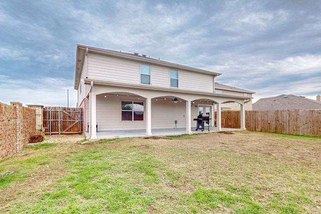 back of house featuring a patio area, ceiling fan, and a yard