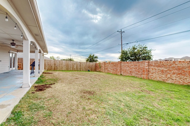 view of yard with ceiling fan and a patio area