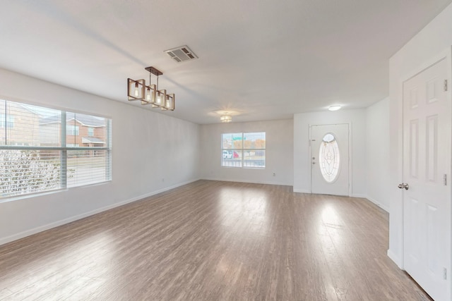 foyer featuring light wood-type flooring and an inviting chandelier