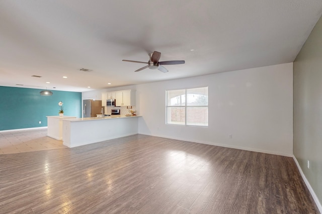 unfurnished living room featuring light hardwood / wood-style flooring and ceiling fan