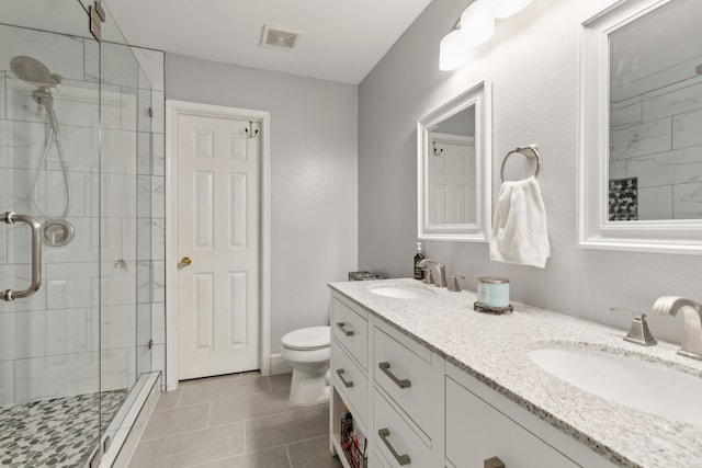 bathroom with tile patterned flooring, vanity, an enclosed shower, and toilet