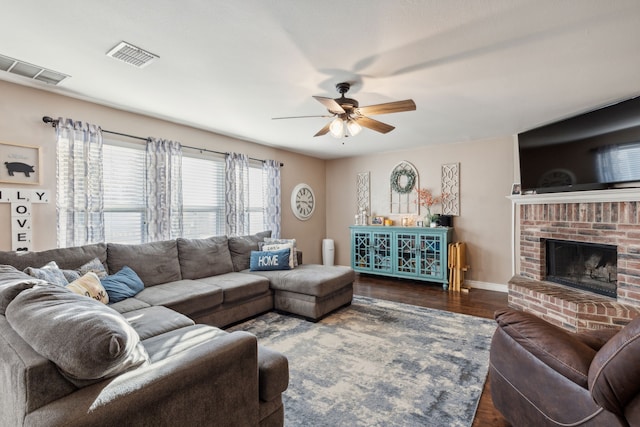 living room with dark hardwood / wood-style floors, ceiling fan, and a fireplace