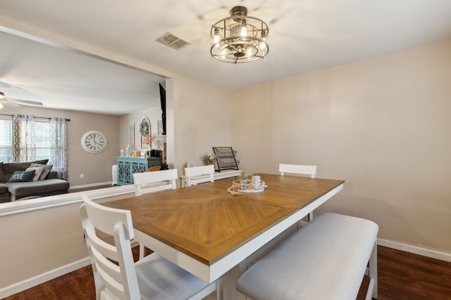 dining area with dark hardwood / wood-style floors and ceiling fan with notable chandelier