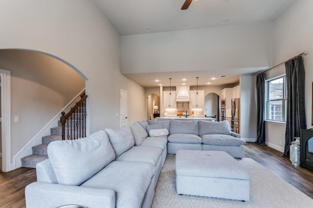 living room featuring ceiling fan, wood-type flooring, and high vaulted ceiling