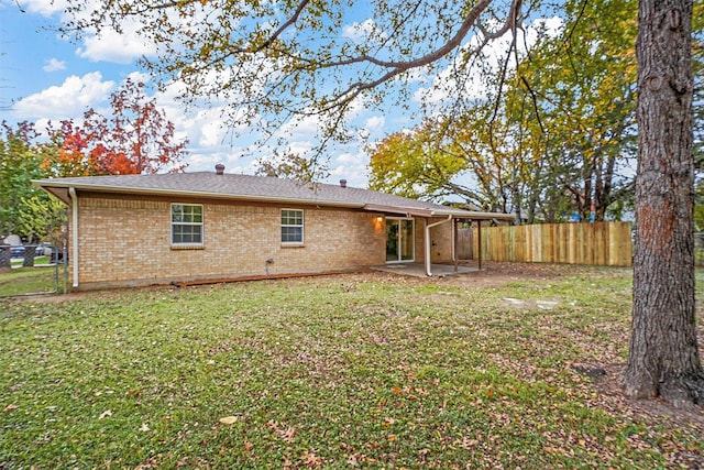 rear view of property with a patio and a lawn