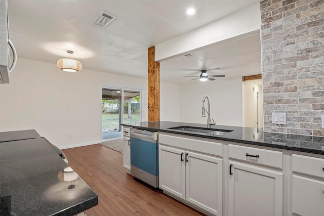 kitchen featuring dishwasher, sink, dark stone counters, wood-type flooring, and white cabinets