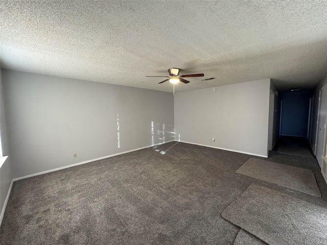 empty room with a textured ceiling, dark carpet, and ceiling fan