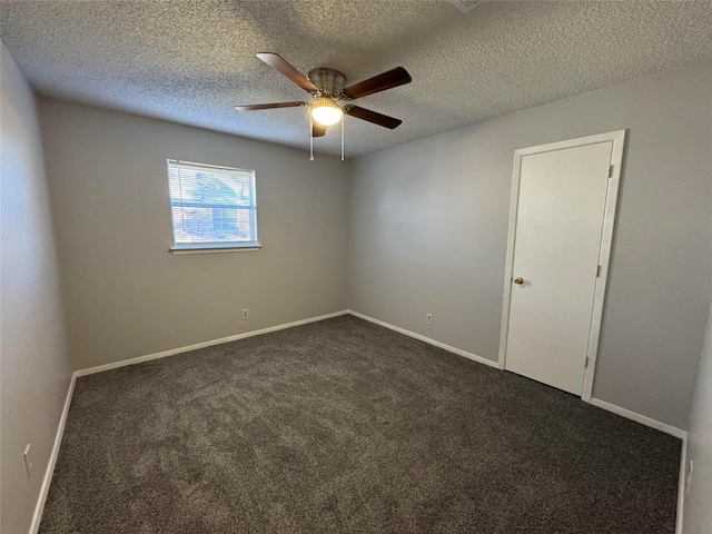 spare room with ceiling fan, a textured ceiling, and dark colored carpet