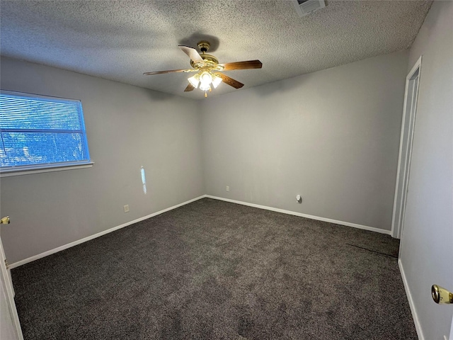 carpeted spare room featuring ceiling fan and a textured ceiling