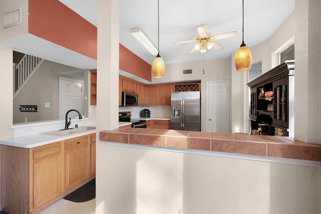 kitchen with sink, ceiling fan, kitchen peninsula, pendant lighting, and appliances with stainless steel finishes