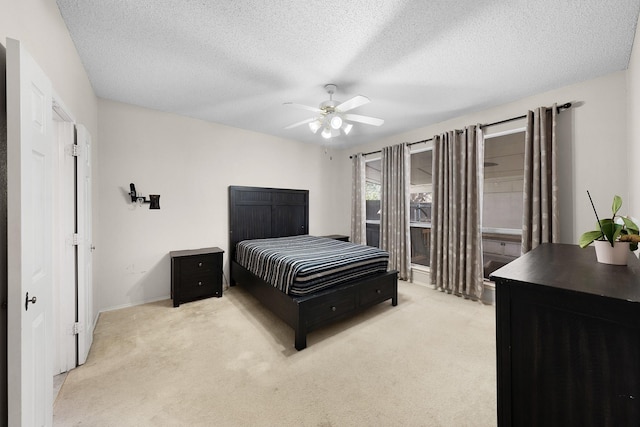 carpeted bedroom with ceiling fan and a textured ceiling