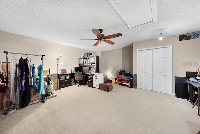 interior space featuring a textured ceiling, ceiling fan, and carpet