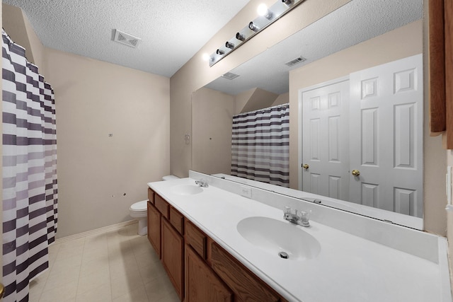 bathroom featuring toilet, a textured ceiling, and vanity