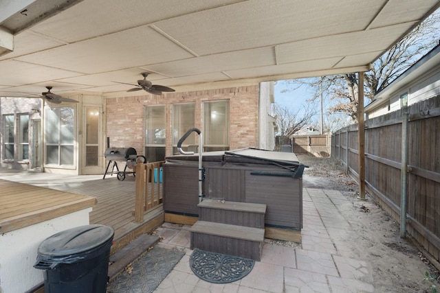 view of patio / terrace with ceiling fan, a hot tub, a wooden deck, and grilling area