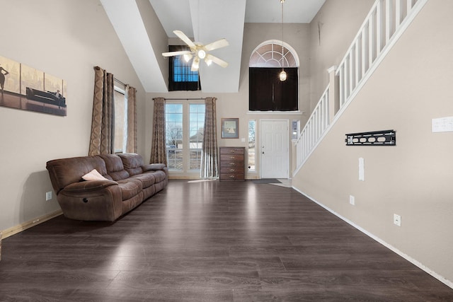 foyer entrance with a high ceiling, dark wood-type flooring, and ceiling fan