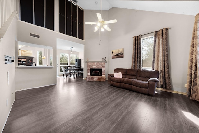 living room with a brick fireplace, high vaulted ceiling, ceiling fan, and dark hardwood / wood-style flooring