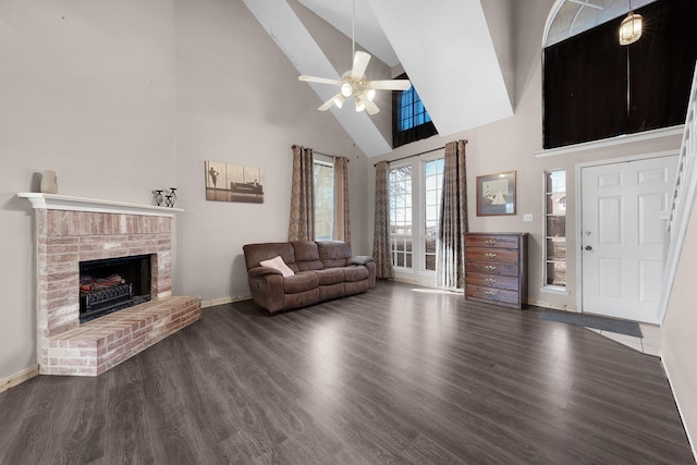 living room featuring ceiling fan, dark hardwood / wood-style flooring, a brick fireplace, and high vaulted ceiling