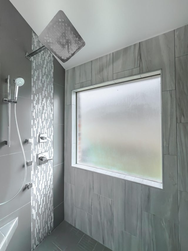 bathroom with tile patterned floors, tiled shower, and tile walls