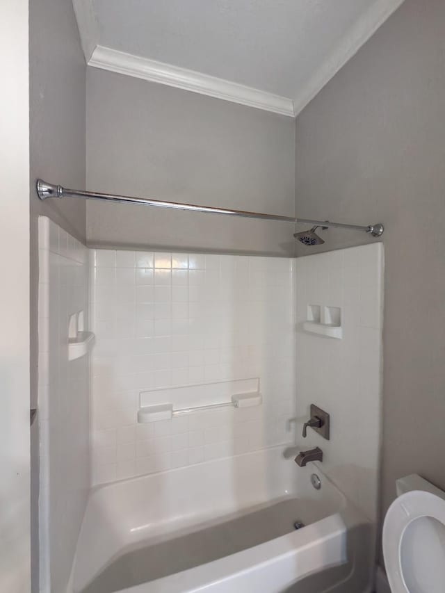 bathroom featuring tiled shower / bath combo, toilet, and ornamental molding