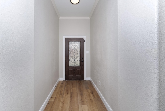 entryway featuring wood-type flooring and crown molding