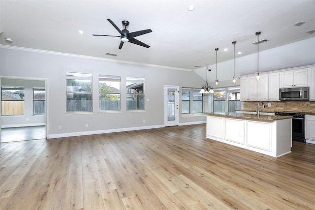 kitchen featuring white cabinets, electric range oven, light wood-type flooring, and hanging light fixtures