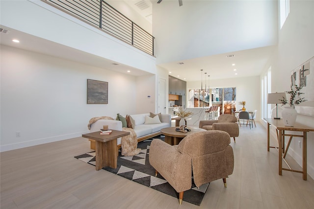 living room featuring a high ceiling and light hardwood / wood-style floors