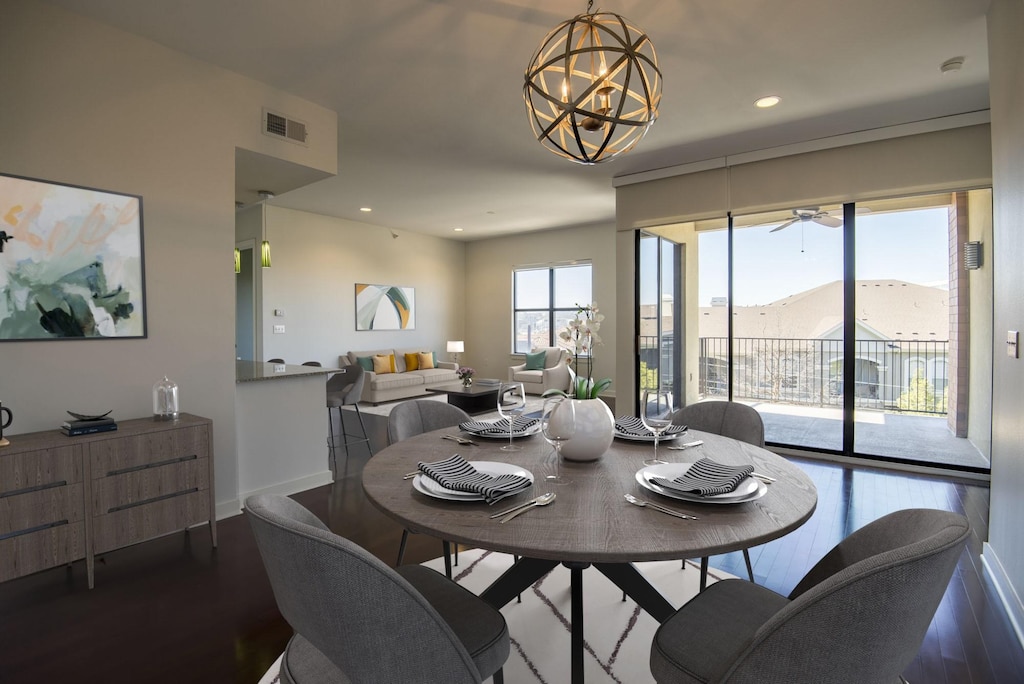 dining area with hardwood / wood-style flooring, a mountain view, and a chandelier