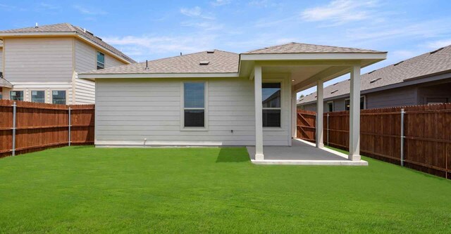 rear view of property featuring a patio and a lawn