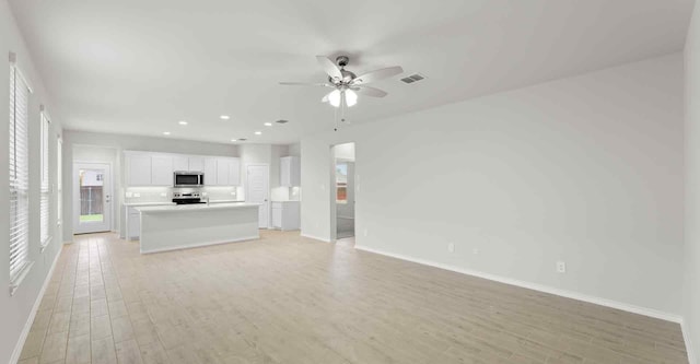 unfurnished living room featuring ceiling fan and light hardwood / wood-style flooring