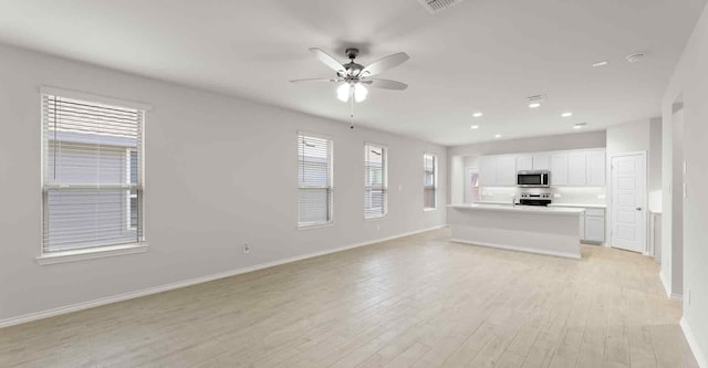 unfurnished living room featuring ceiling fan and light hardwood / wood-style floors