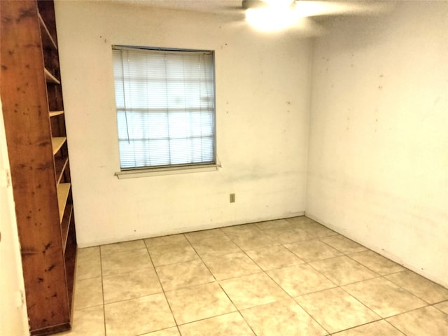 tiled spare room with ceiling fan