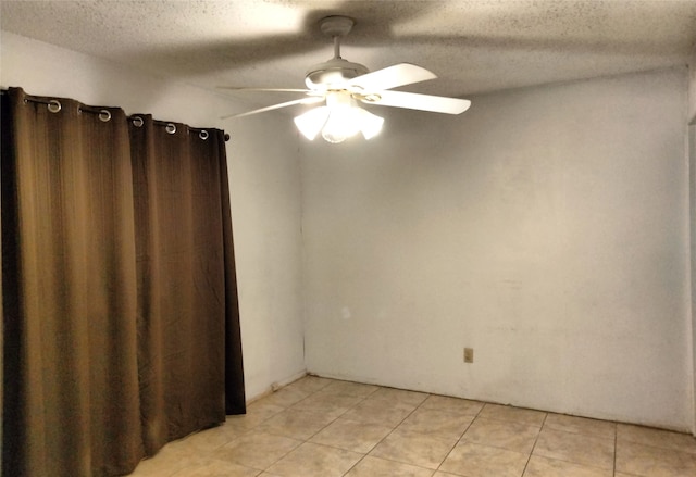 tiled empty room featuring a textured ceiling and ceiling fan