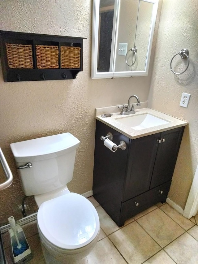 bathroom with tile patterned flooring, vanity, and toilet