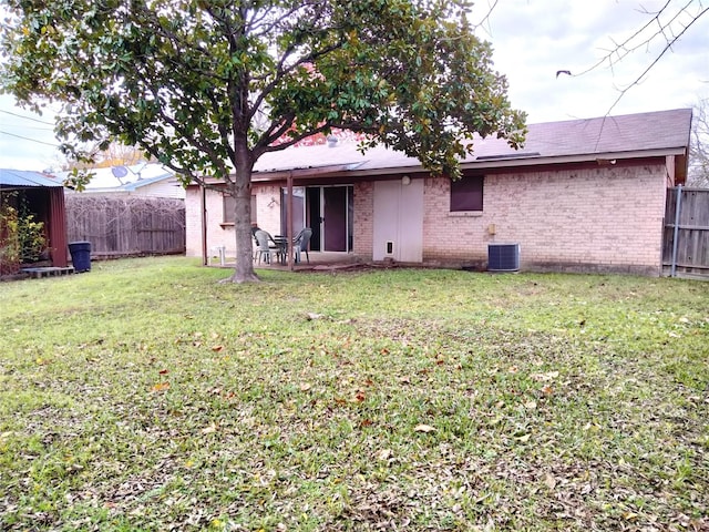 back of house featuring a lawn and central AC unit