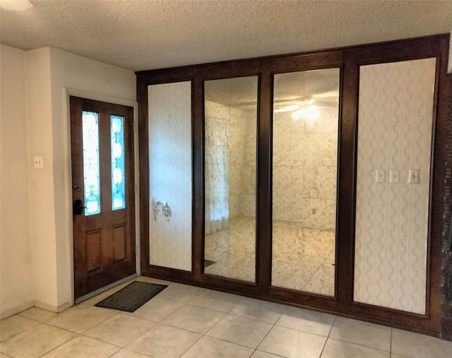 tiled entryway with a textured ceiling