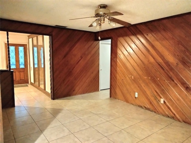 empty room with ceiling fan and wooden walls