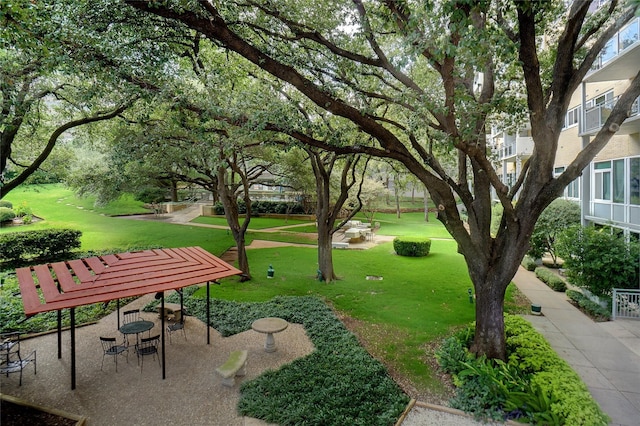 surrounding community featuring a lawn and a patio area