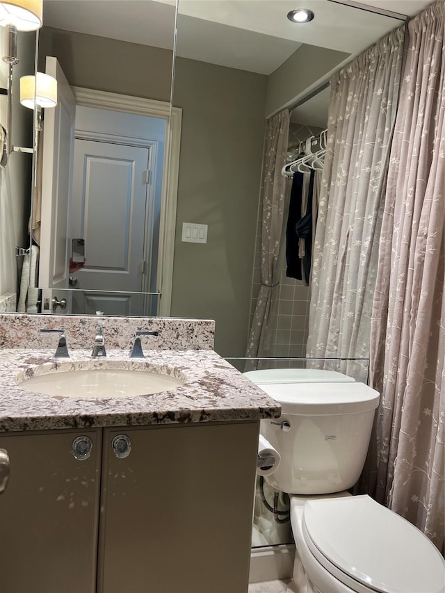 bathroom featuring walk in shower, vanity, and toilet