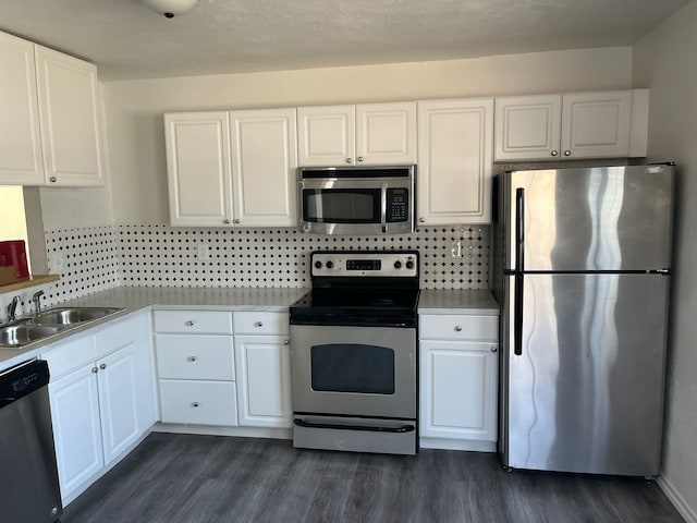 kitchen with dark hardwood / wood-style flooring, backsplash, stainless steel appliances, sink, and white cabinets