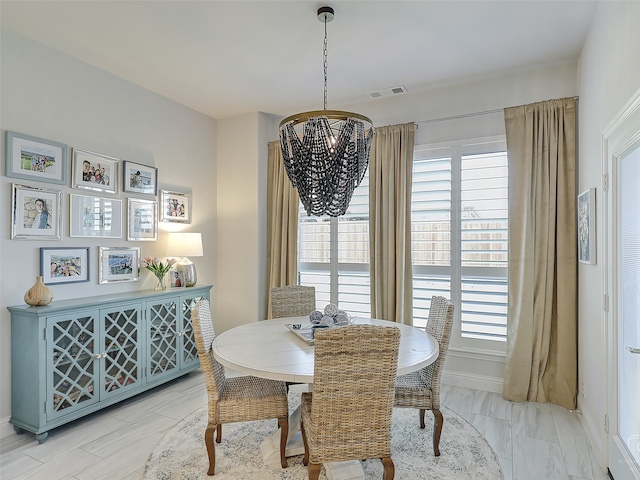 dining space featuring a wealth of natural light and an inviting chandelier