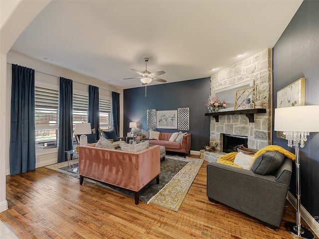 living room featuring ceiling fan, a fireplace, and hardwood / wood-style flooring