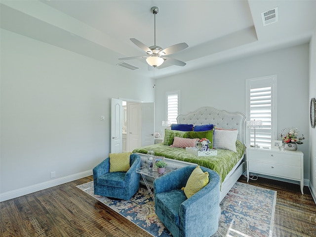 bedroom featuring ceiling fan, dark wood-type flooring, and multiple windows