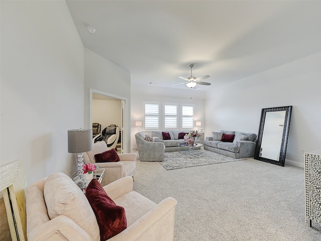 living room featuring ceiling fan, a fireplace, and light colored carpet