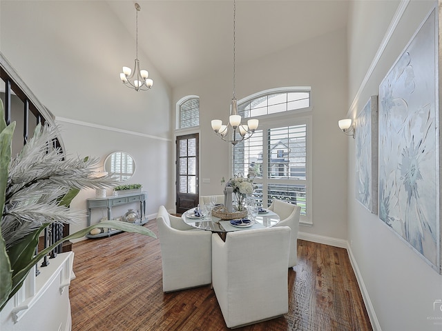 dining area featuring dark hardwood / wood-style flooring, high vaulted ceiling, and an inviting chandelier