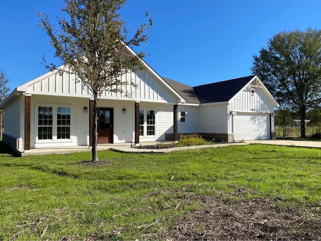 view of front of property featuring a porch, a garage, and a front yard